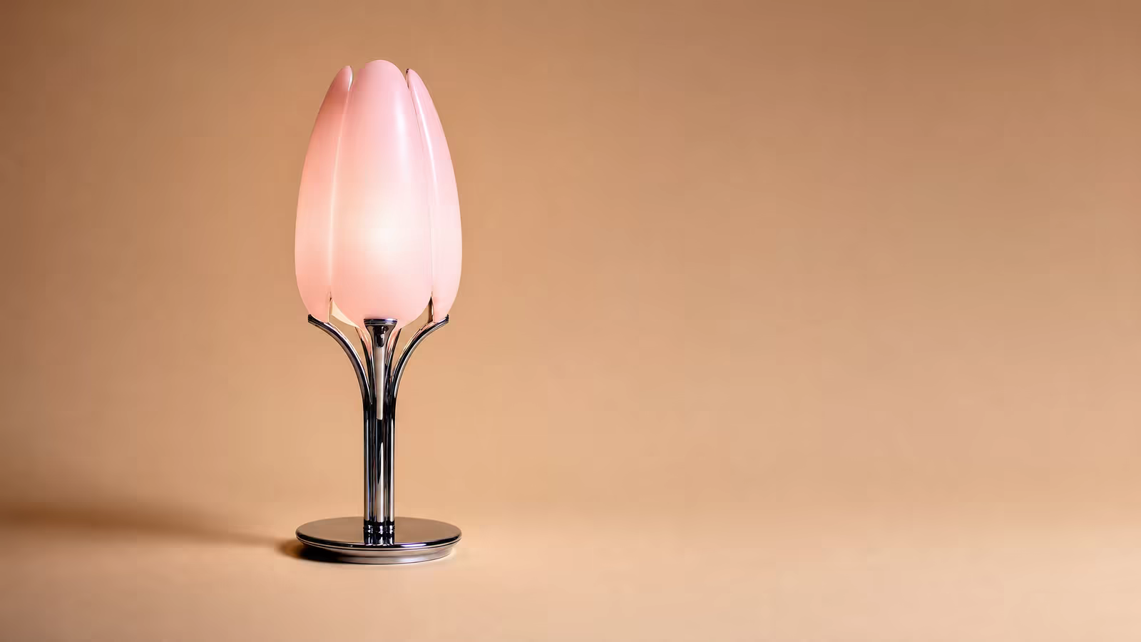 The lamp lit on a caramel sweep, set to the left third with clean negative space to the right