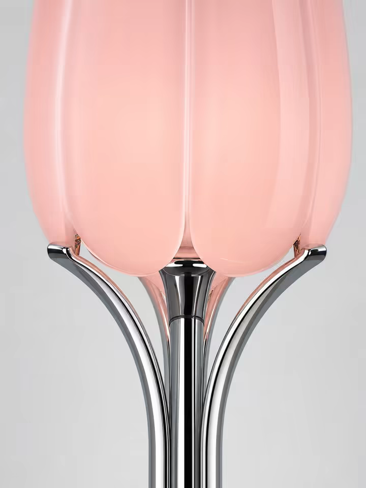 A macro frame of the four chrome arms cupping the pink glass petals