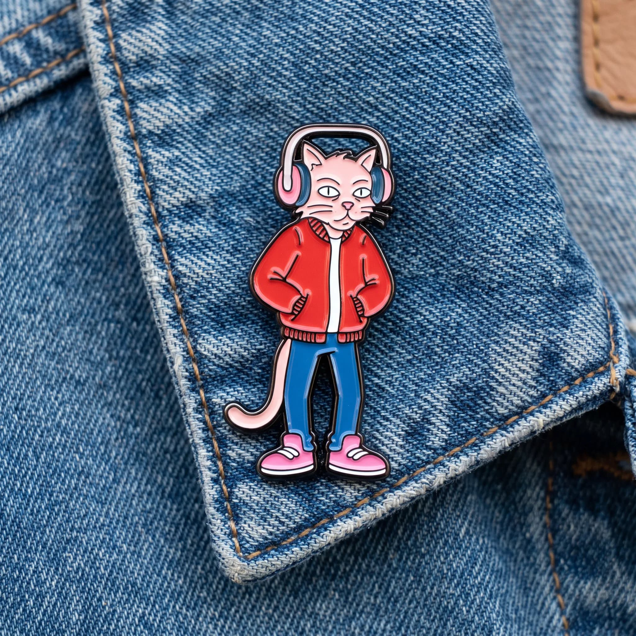 Hard enamel pin of a lanky alley cat DJ on denim, Panty and Stocking art style