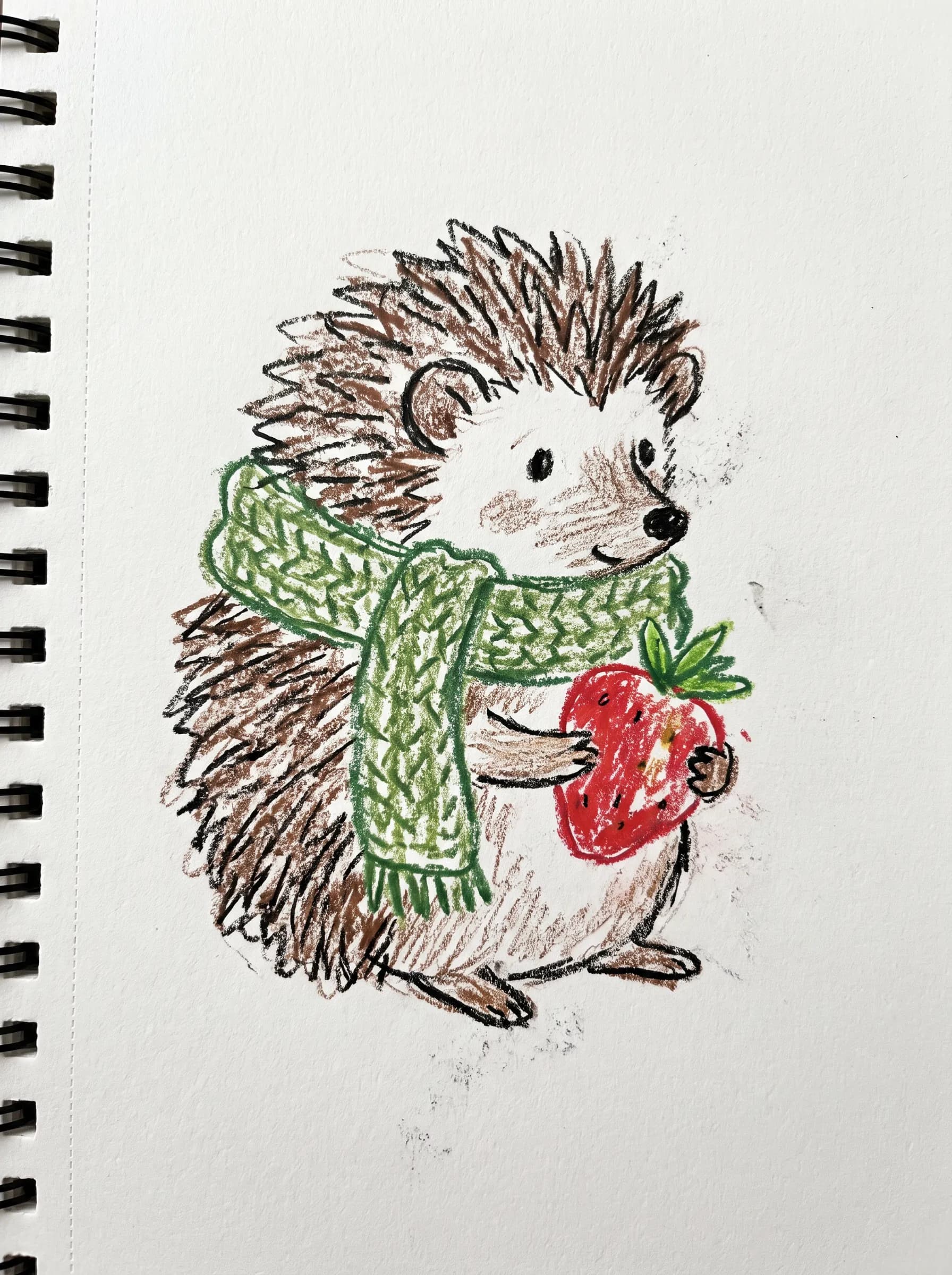 Crayon doodle of a little hedgehog in a knitted green scarf holding a strawberry