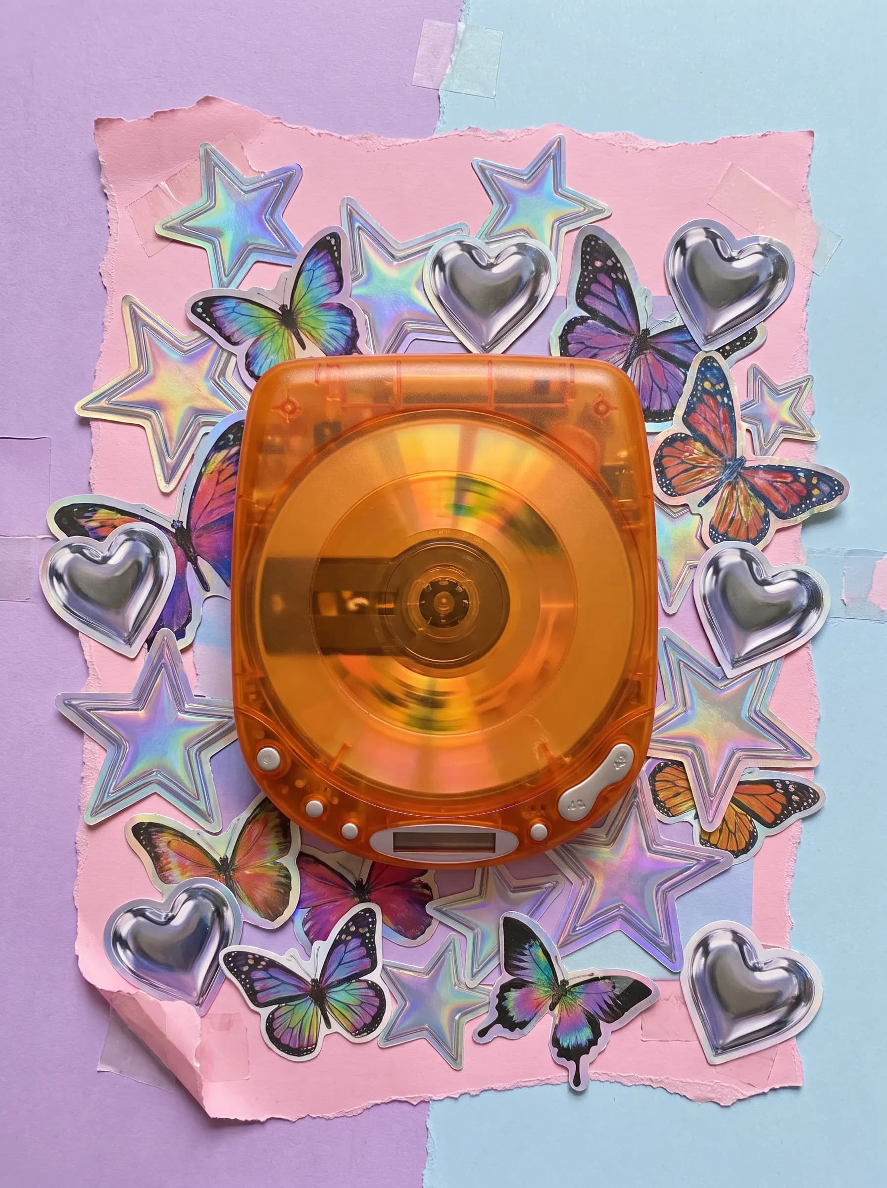 Magazine cutout collage around a translucent tangerine portable CD player, Y2K art style