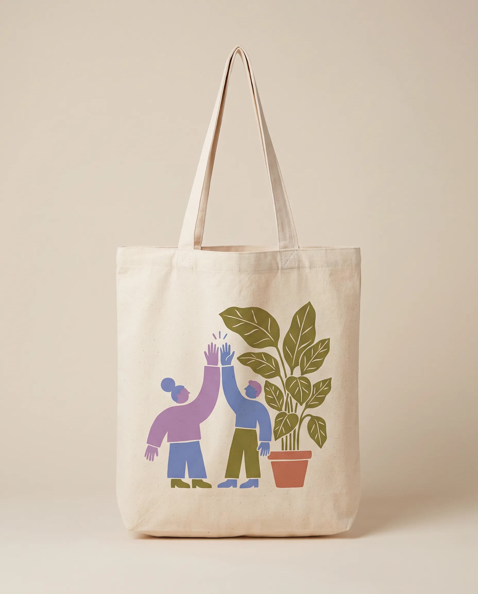 Screen-printed tote bag showing two coworkers with purple and blue skin high-fiving beside a giant potted plant