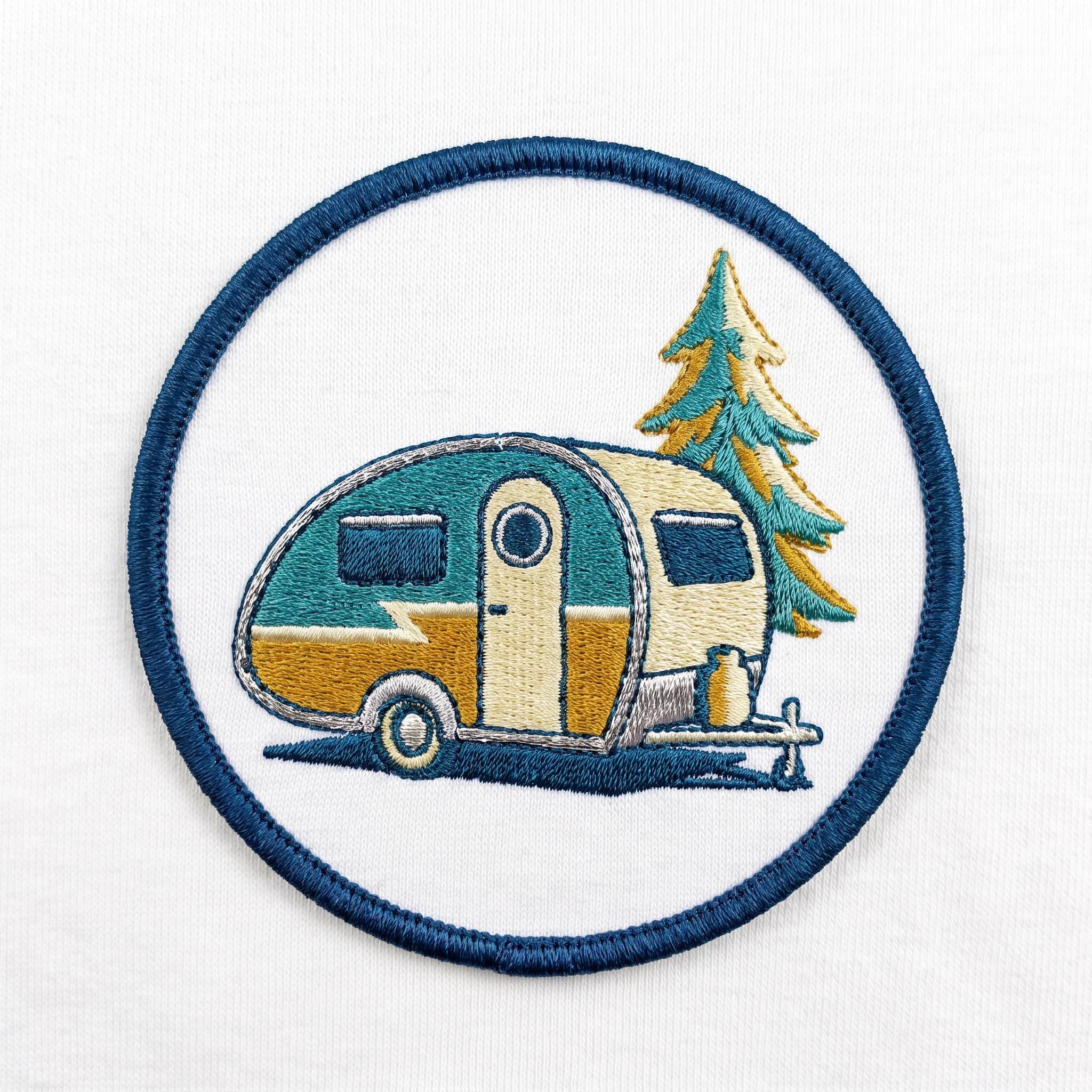 Embroidered patch of a teardrop camper trailer under a pine tree, retro art style