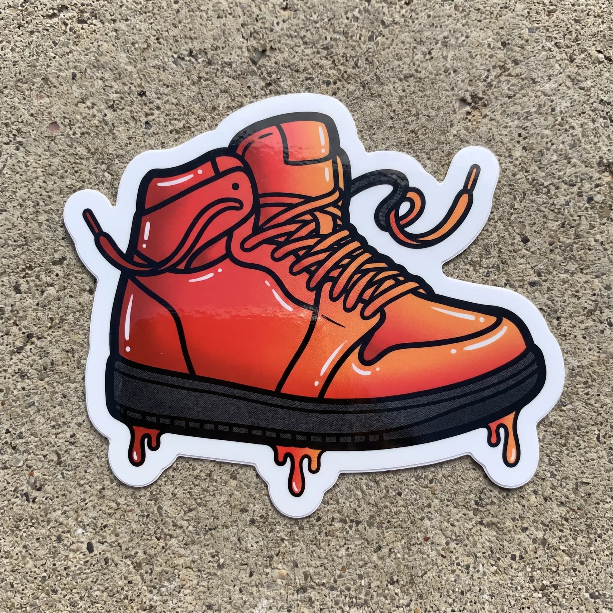 Die-cut vinyl sticker of a chunky high-top sneaker with flying laces, graffiti art style