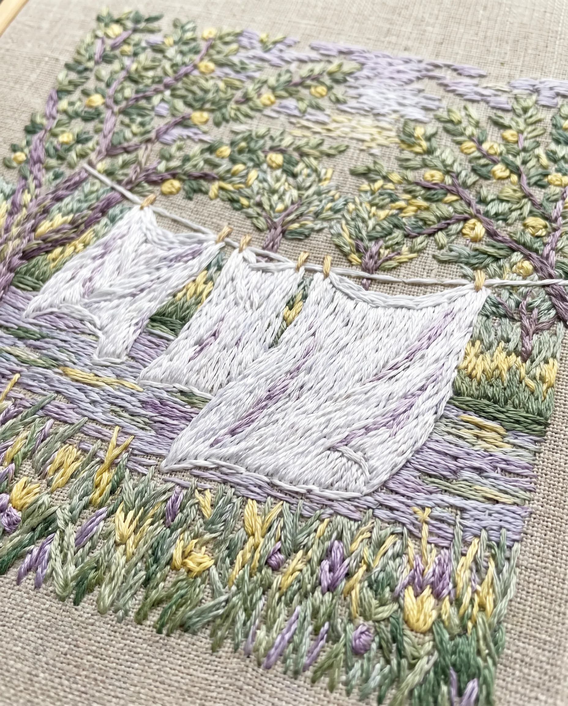 Embroidered panel of white sheets drying in a breezy riverside orchard, Claude Monet art style