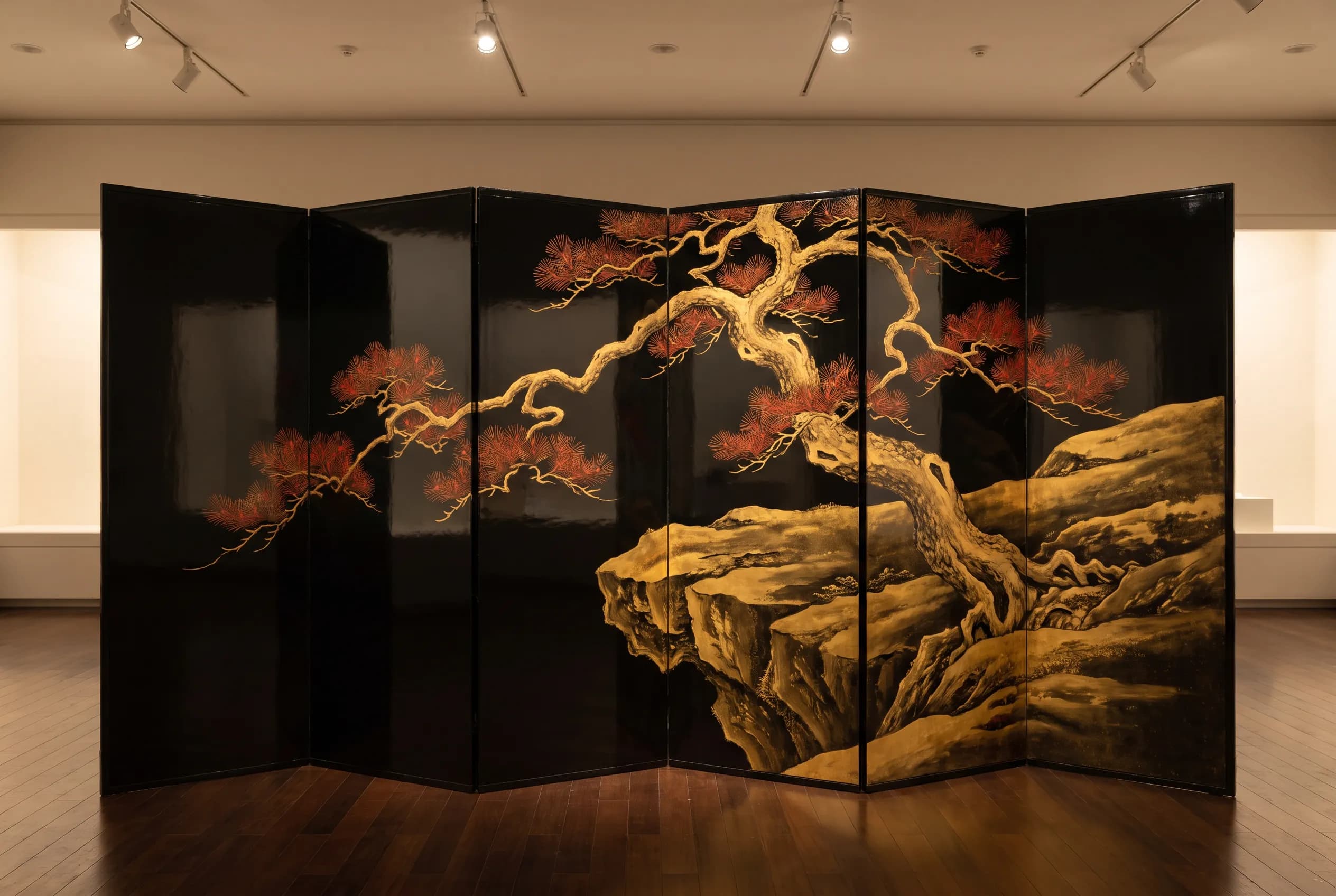 Six-panel black lacquer folding screen painted in gold with a pine on a rocky ledge, Chinese art style